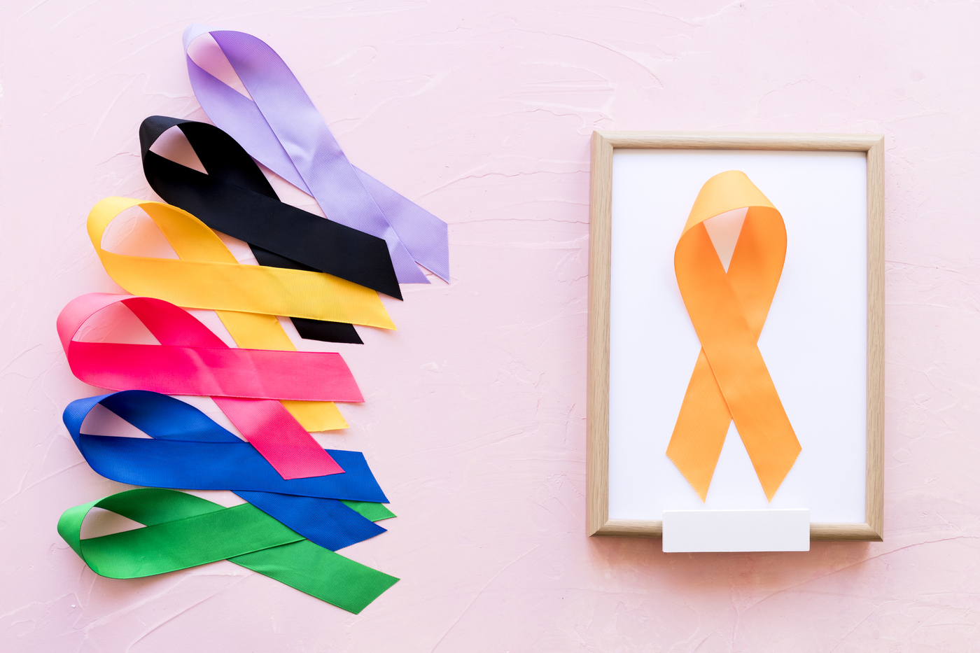 yellow-ribbon-on-white-wooden-frame-near-the-row-of-colorful-awareness-ribbon (2)